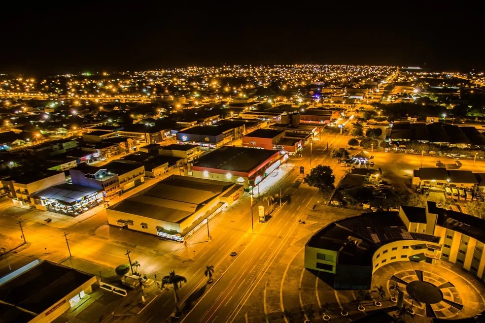 Vista aérea noturna de Ariquemes, com avenidas e comércio iluminados