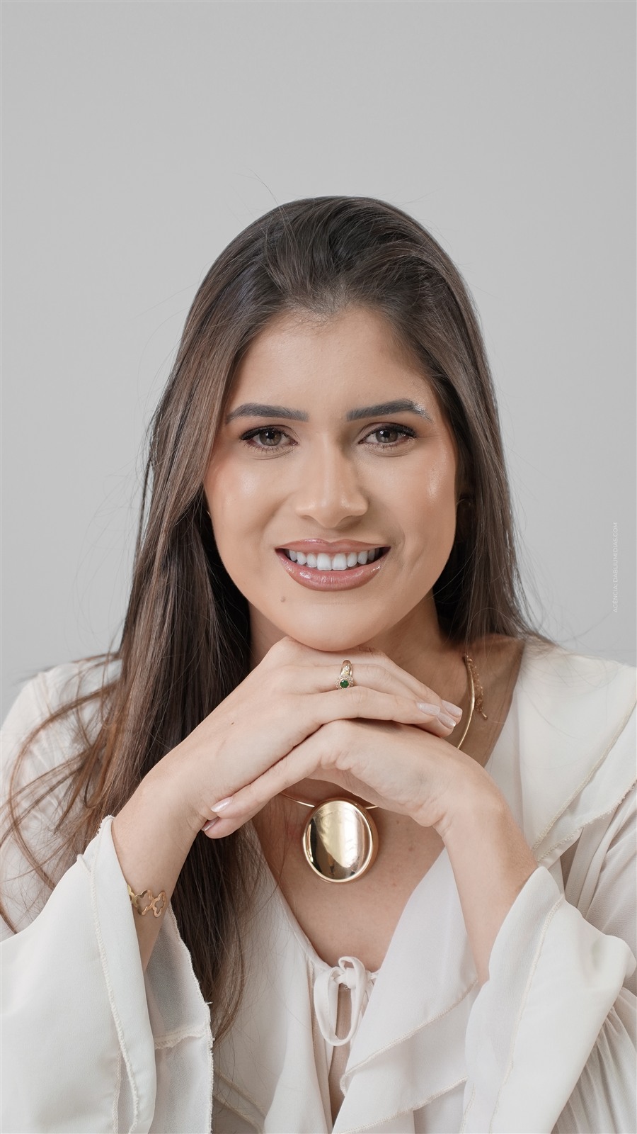 Ensaio corporativo em Ariquemes da profissional de estética Luana Lacerda, retrato sorrindo com as mãos no queixo